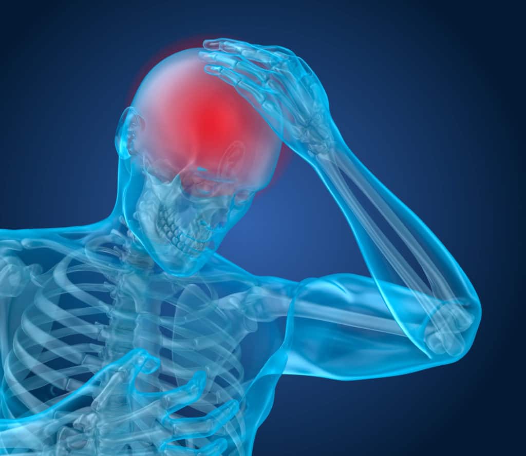 man holding head in pain from a concussion